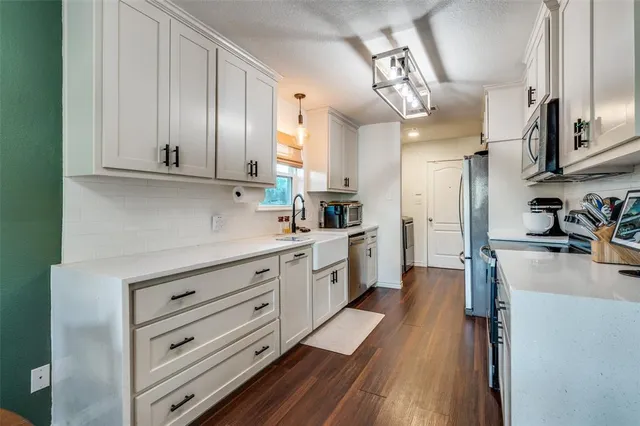 a large kitchen with cabinets wooden floor and stainless steel appliances