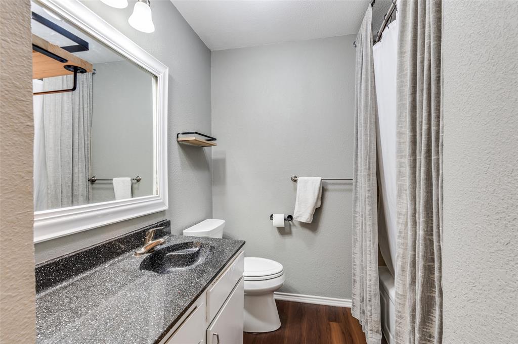 3700 Wedgworth Road South Fort Worth, TX 76133 - Photo 10 of 12 a bathroom with a granite countertop sink toilet and mirror