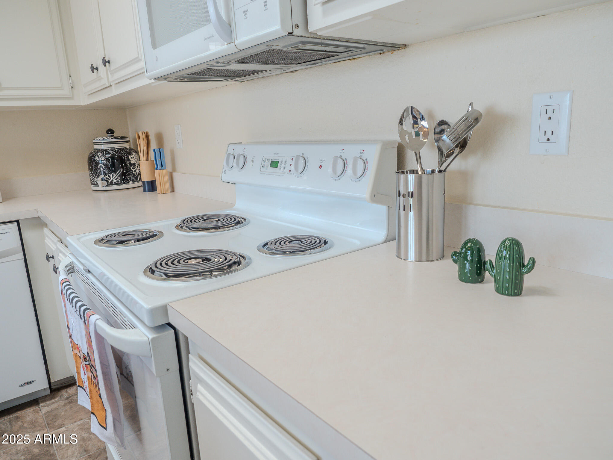 8865 East Baseline Road, Unit 1207 Mesa, AZ 85209 - Photo 18 of 40 a kitchen with a sink a stove and white cabinets
