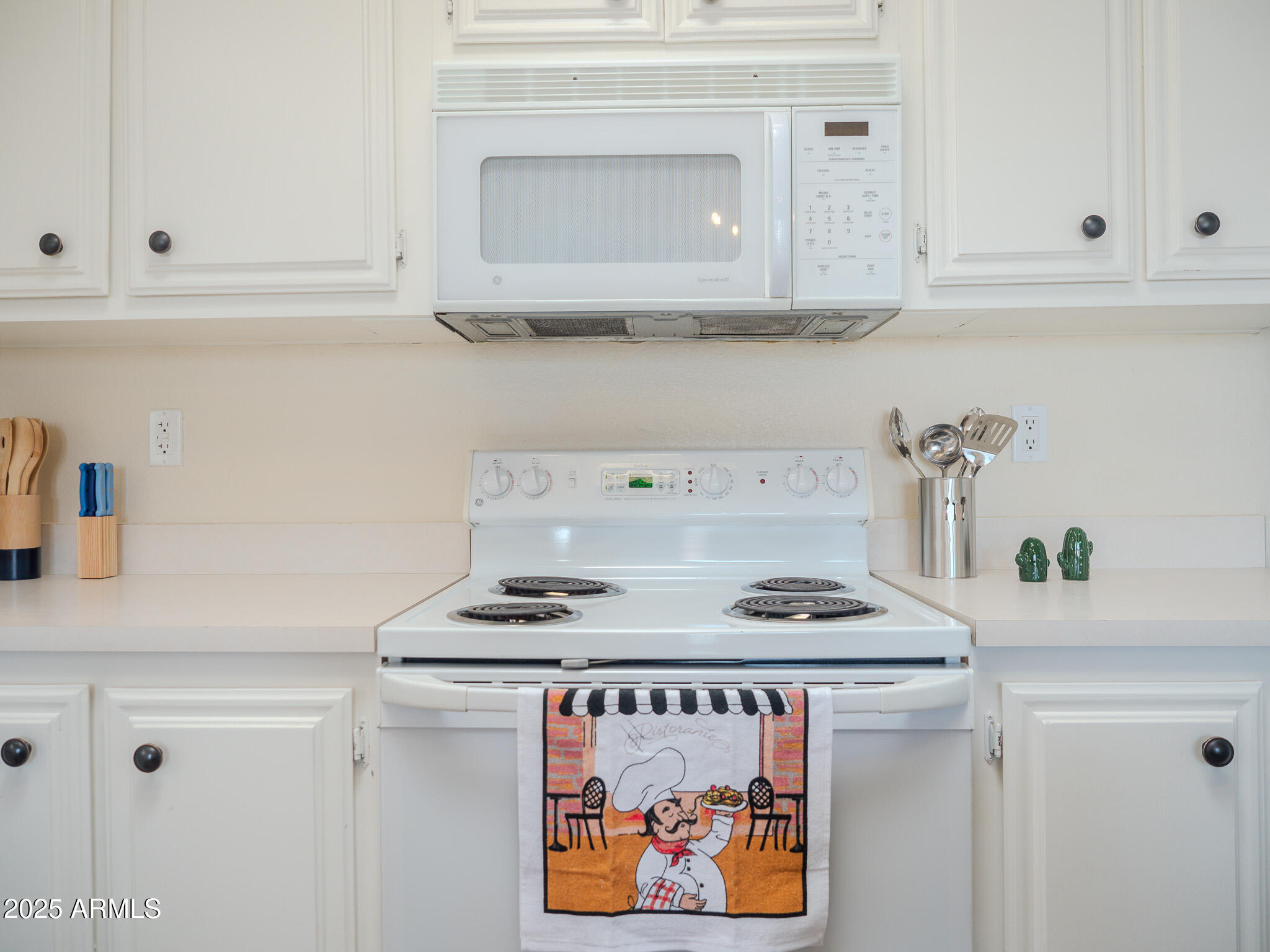 8865 East Baseline Road, Unit 1207 Mesa, AZ 85209 - Photo 20 of 40 a kitchen with white cabinets and a stove with a wooden floor
