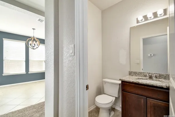 a bathroom with a granite countertop sink a toilet and a mirror