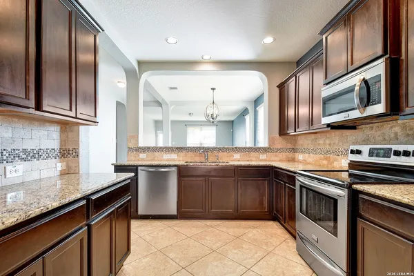a kitchen with stainless steel appliances granite countertop a sink and stove top oven
