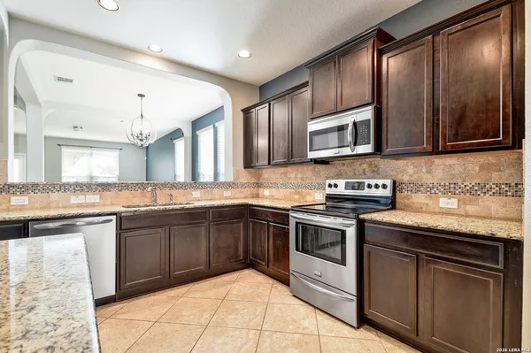 a kitchen with stainless steel appliances granite countertop a stove microwave and sink