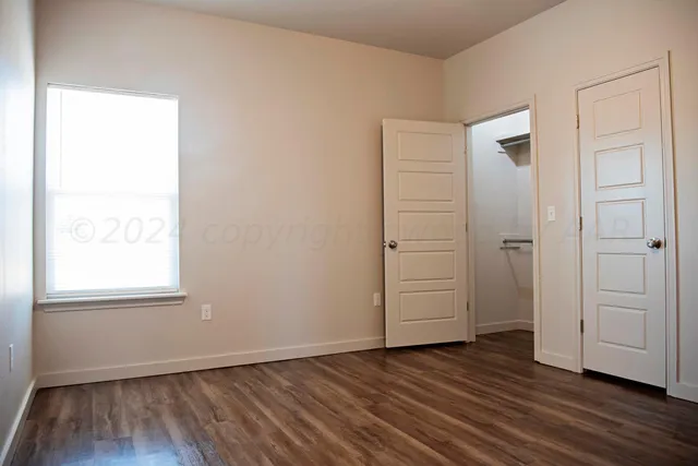 a view of a room with wooden floor and fan