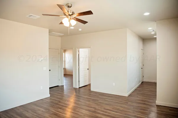 a view of a hallway with wooden floor and a bathroom
