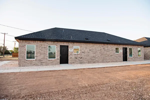 a front view of house with yard outdoor seating and house in the background