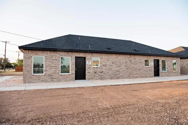 a front view of house with yard outdoor seating and house in the background
