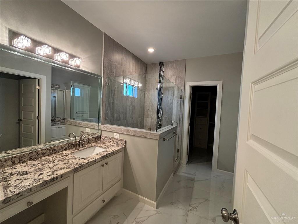2601 Tulipan Avenue Mission, TX 78574 - Photo 17 of 27 a bathroom with a granite countertop sink a mirror and a shower