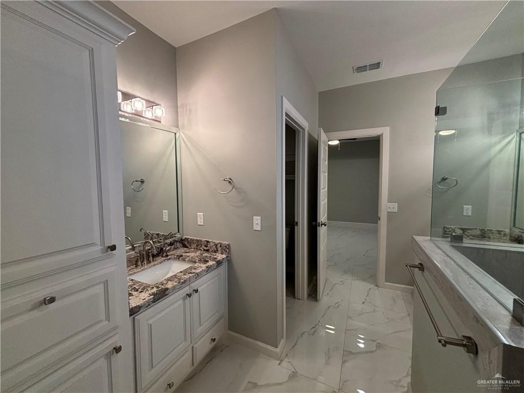 2601 Tulipan Avenue Mission, TX 78574 - Photo 18 of 27 a spacious bathroom with a granite countertop sink a mirror and a shower