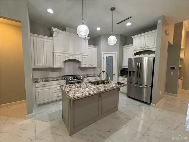 a kitchen with stainless steel appliances granite countertop a stove refrigerator and cabinets