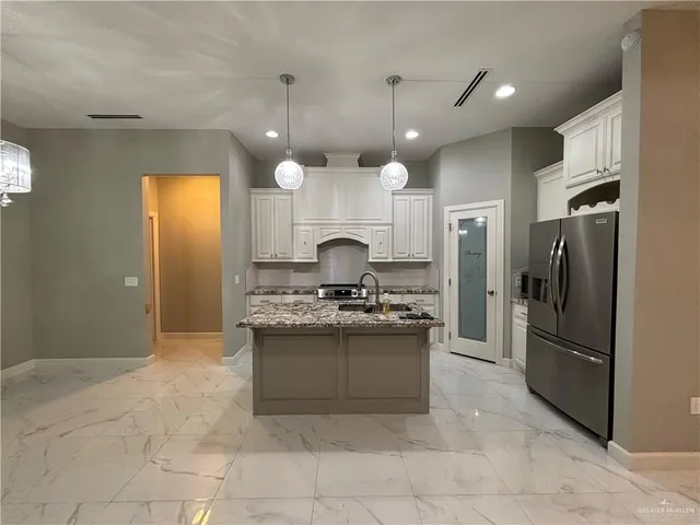 a kitchen with stainless steel appliances granite countertop a stove and a refrigerator