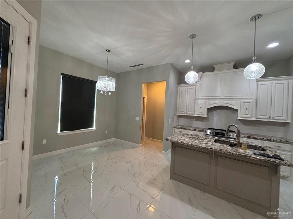 2601 Tulipan Avenue Mission, TX 78574 - Photo 6 of 27 a kitchen with kitchen island granite countertop a stove a sink a counter space and cabinets