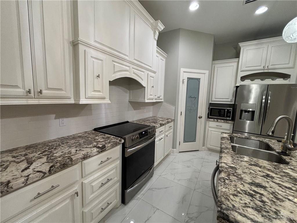 2601 Tulipan Avenue Mission, TX 78574 - Photo 7 of 27 a kitchen with granite countertop a stove sink and cabinets
