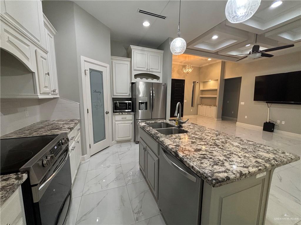 2601 Tulipan Avenue Mission, TX 78574 - Photo 8 of 27 a kitchen with stainless steel appliances granite countertop a sink stove and refrigerator