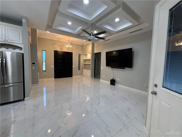 a view of a livingroom with a kitchen space and a flat screen tv