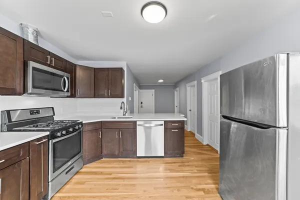 a kitchen with stainless steel appliances granite countertop a refrigerator stove top oven and sink
