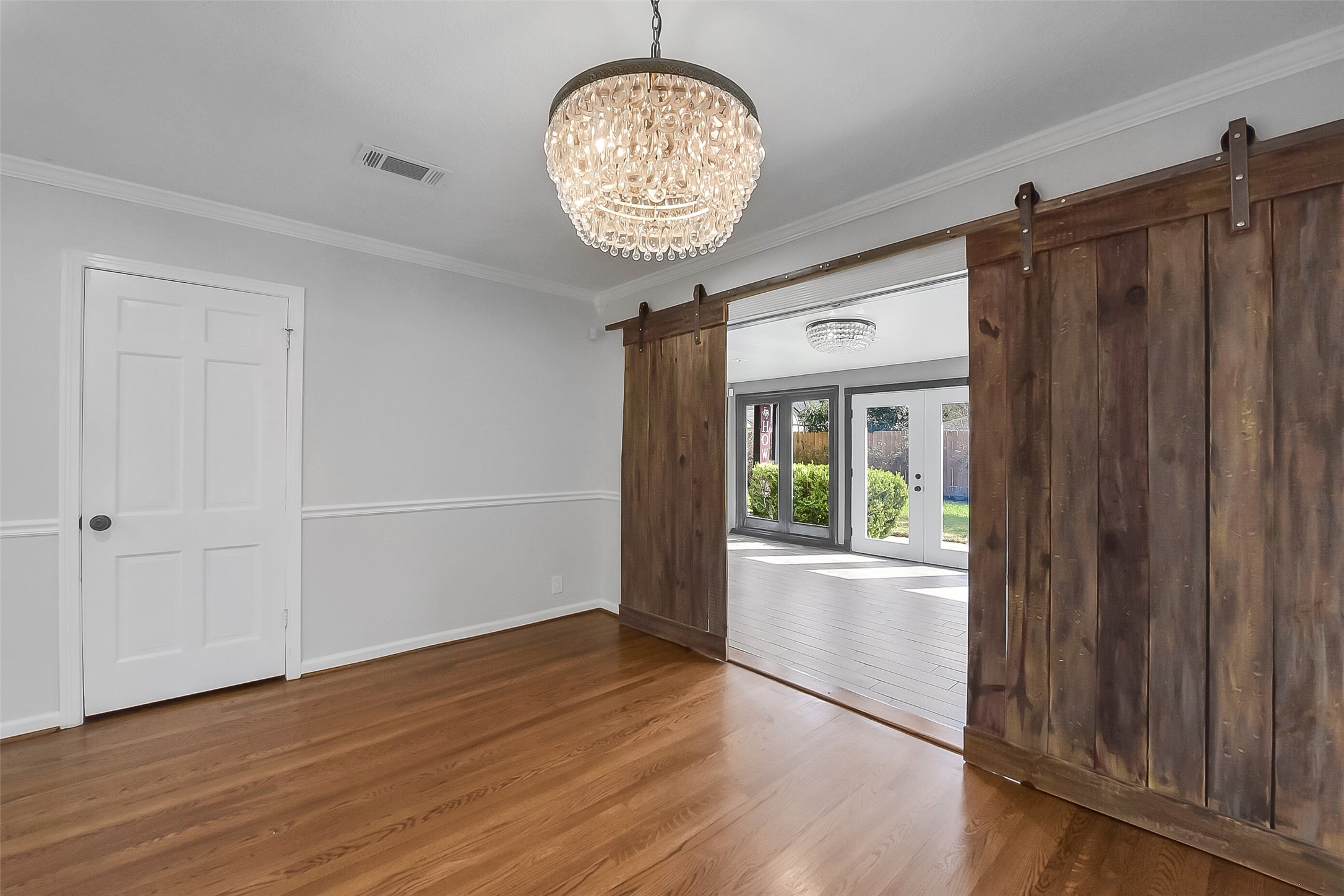 9623 Val Verde Street Houston, TX 77063 - Photo 12 of 26 Another view of the dining area showcasing wood flooring & sliding barn doors leading to sunroom — blending charm & functionality. Closet to the left.
