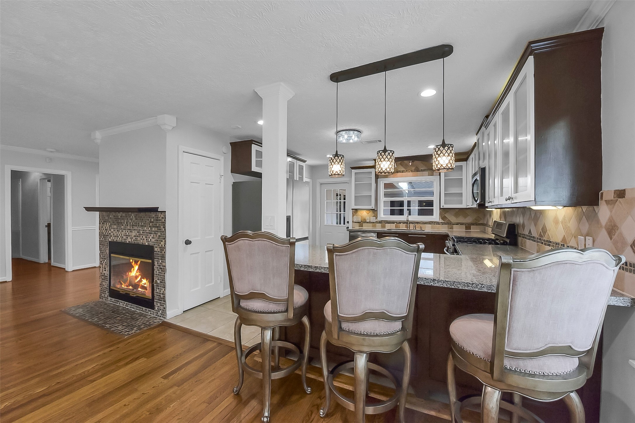 9623 Val Verde Street Houston, TX 77063 - Photo 6 of 26 Breakfast bar w/three pendant lights, provides casual seating & a natural transition into the kitchen workspace.