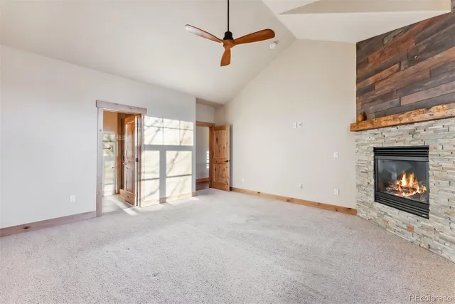 a view of an empty room with a fireplace and a window