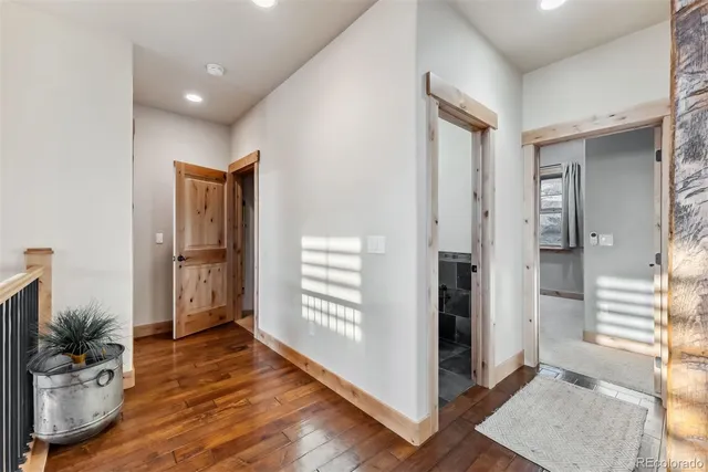a view of a hallway with a livingroom and a hall with wooden floor