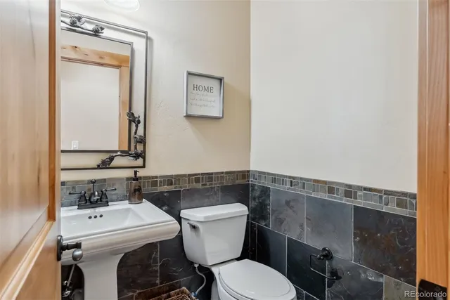 a bathroom with a sink a toilet and a mirror