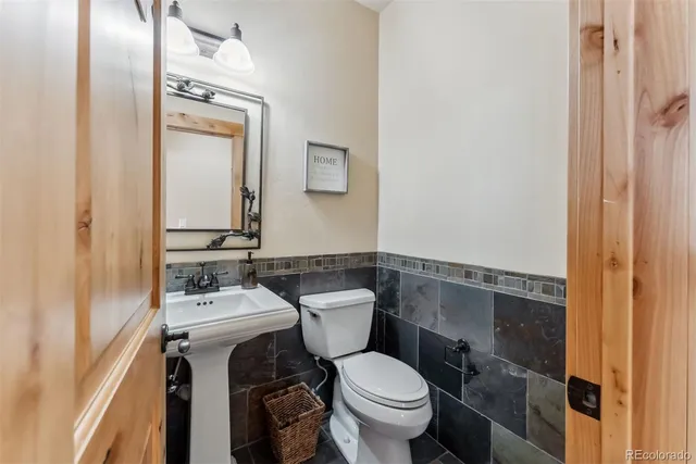 a bathroom with a toilet a sink and mirror