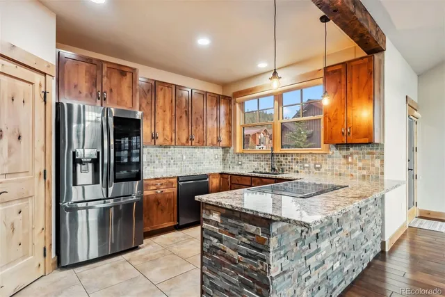a kitchen with stainless steel appliances granite countertop a sink stove and refrigerator