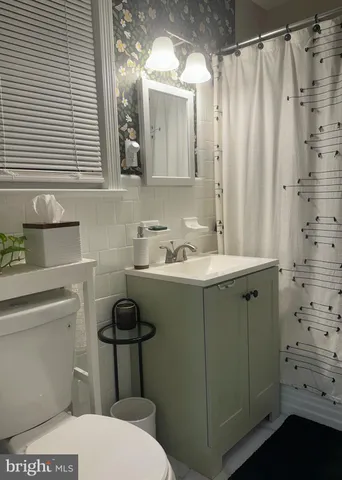 a bathroom with a sink a toilet and shower curtain