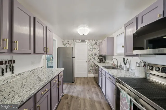 a kitchen with stainless steel appliances granite countertop a sink stove microwave and refrigerator