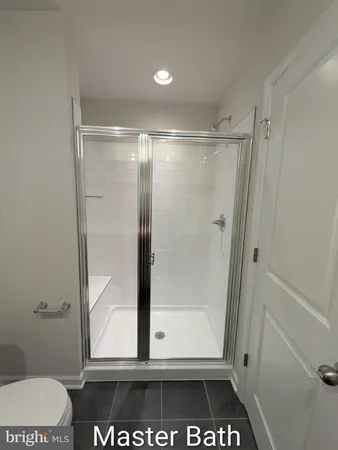 a bathroom with a glass door shower and toilet