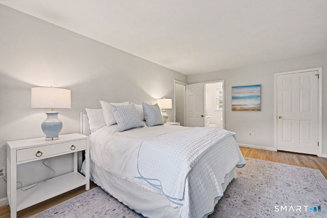 370 Nepas Road Fairfield, CT 06825 - Photo 18 of 32 a spacious bedroom with a bed and a lamp