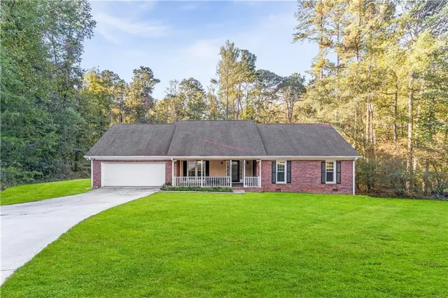 aerial view of a house next to a big yard and large trees