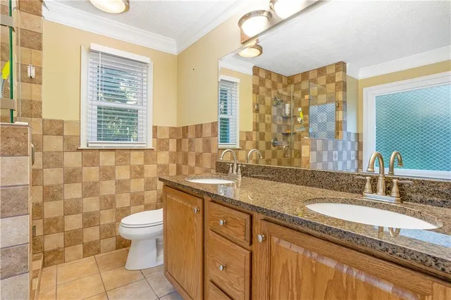 a bathroom with a granite countertop sink toilet and shower