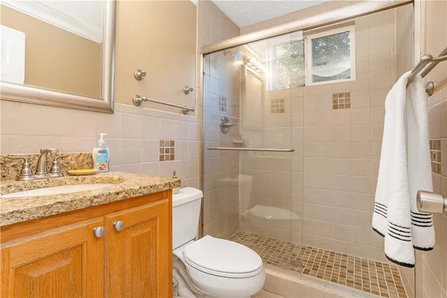 a bathroom with a granite countertop sink toilet and shower