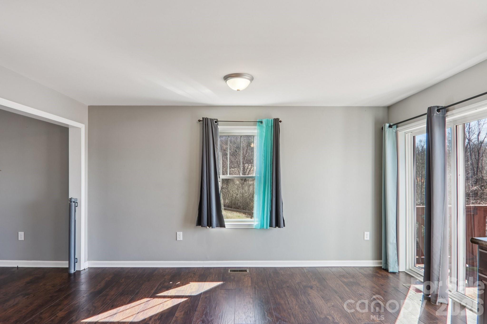751 Hutch Mountain Road Fletcher, NC 28732 - Photo 16 of 48 an empty room with wooden floor and windows