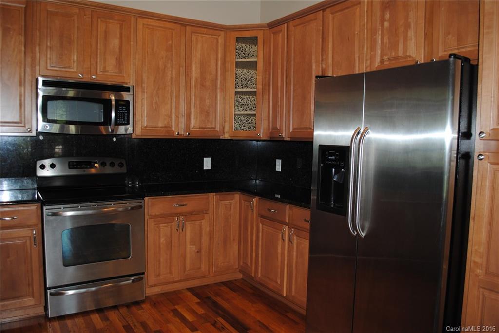 975 Jackson Road Salisbury, NC 28146 - Photo 6 of 24 a kitchen with stainless steel appliances wooden cabinets and a stove