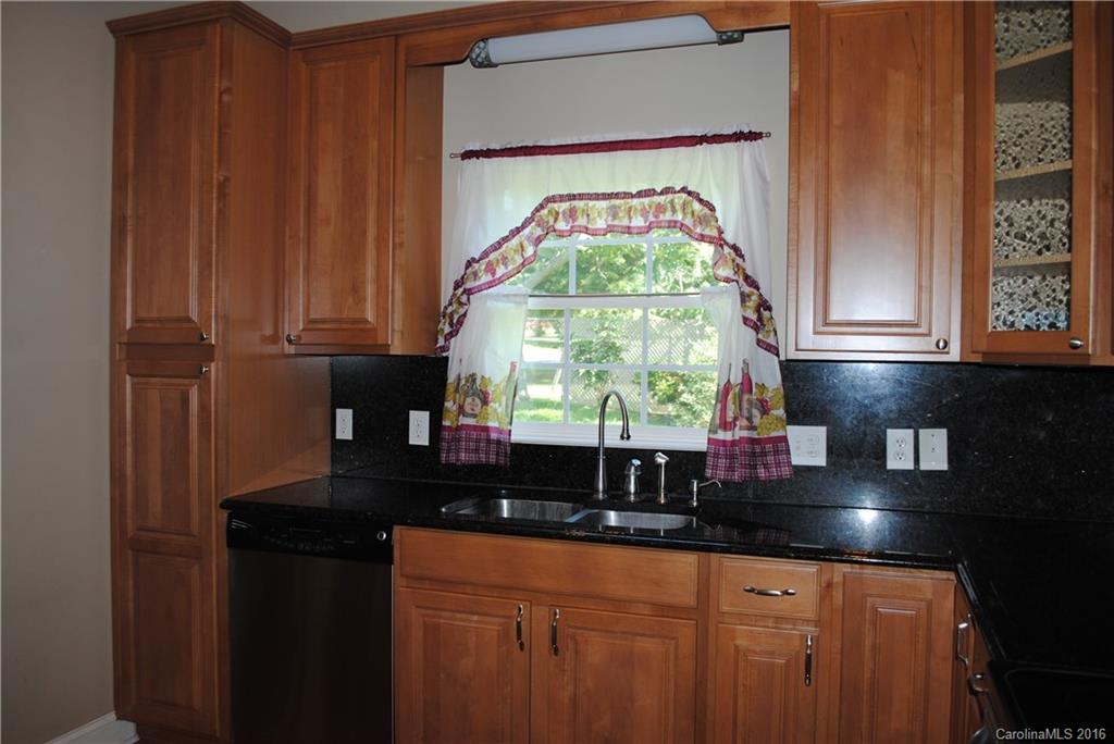 975 Jackson Road Salisbury, NC 28146 - Photo 7 of 24 a kitchen with stainless steel appliances granite countertop a sink a stove and a wooden cabinets