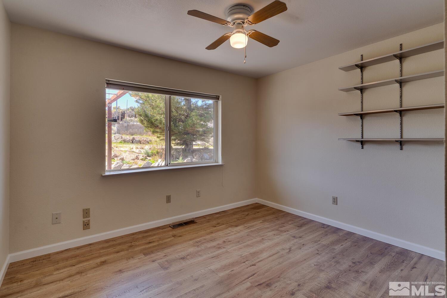 16015 Rocky Vista Road Reno, NV 89521 - Photo 14 of 20 an empty room with wooden floor fan and windows