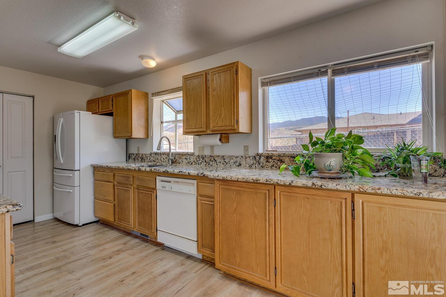 16015 Rocky Vista Road Reno, NV 89521 - Photo 7 of 20 a kitchen with stainless steel appliances granite countertop a sink and a refrigerator