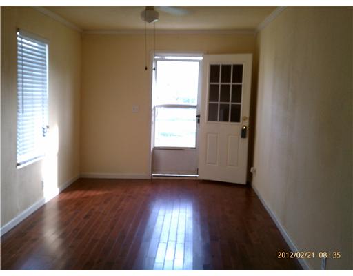 401 Moore Portland, TX 78374 - Photo 3 of 8 an empty room with wooden floor and windows