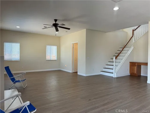 a view of a livingroom with wooden floor and staircase