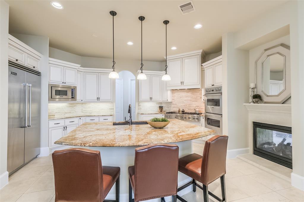a kitchen with granite countertop a table chairs stainless steel appliances and cabinets
