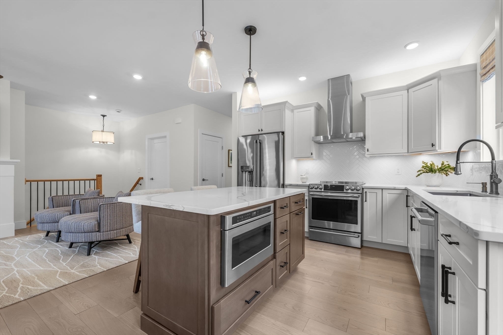 28 Oxbow Road, Unit 142 Raynham, MA 02767 - Photo 11 of 42 a kitchen with kitchen island a stove a sink a center island a stove and a window