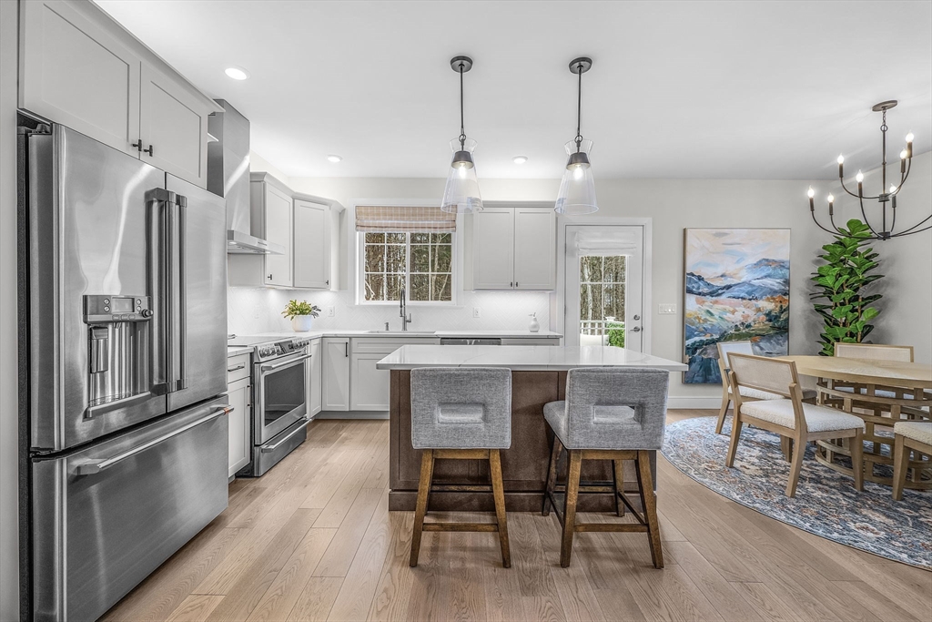 28 Oxbow Road, Unit 142 Raynham, MA 02767 - Photo 13 of 42 a kitchen with granite countertop a refrigerator a table and chairs in it