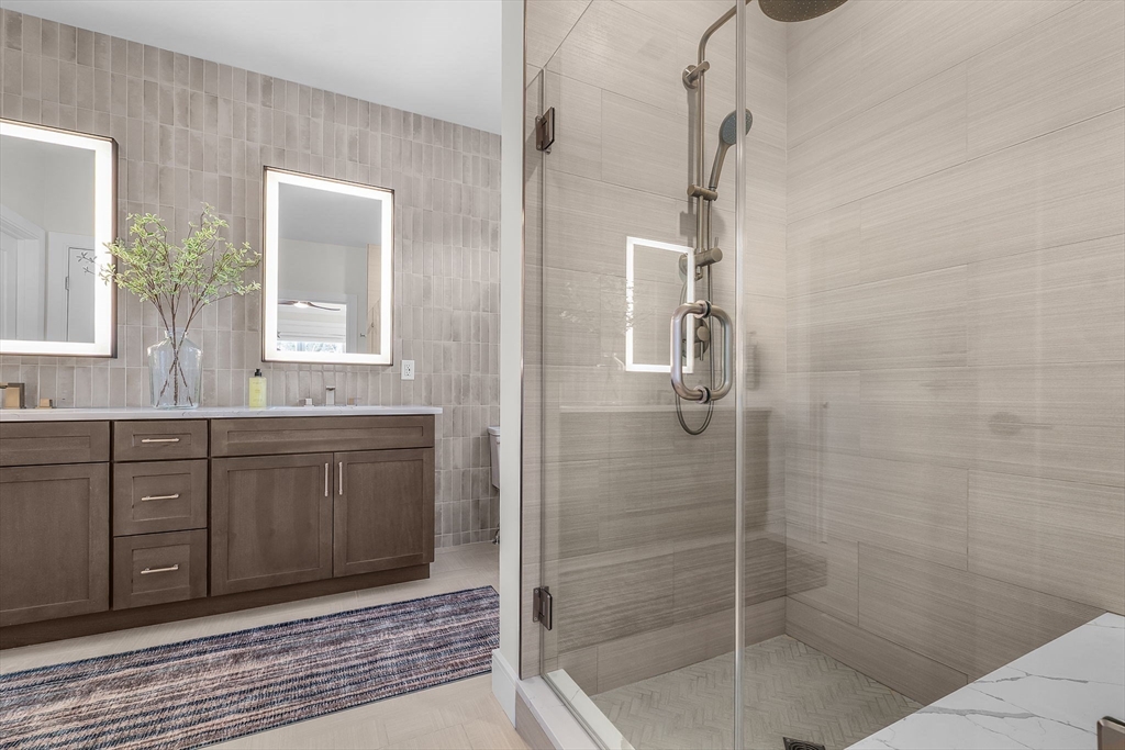 28 Oxbow Road, Unit 142 Raynham, MA 02767 - Photo 18 of 42 a bathroom with a shower sink and mirror