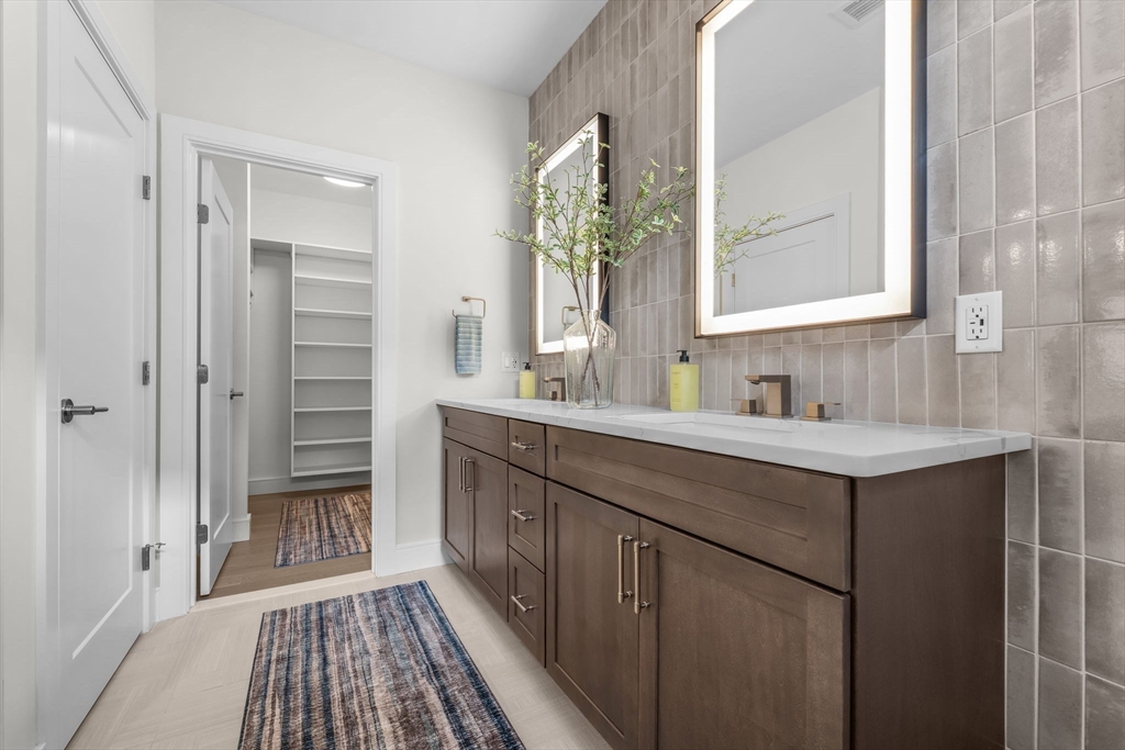 28 Oxbow Road, Unit 142 Raynham, MA 02767 - Photo 20 of 42 a bathroom with a double vanity sink a mirror and a shower