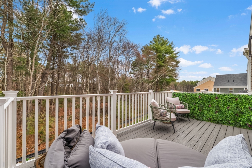 28 Oxbow Road, Unit 142 Raynham, MA 02767 - Photo 28 of 42 a roof deck with couches and wooden fence