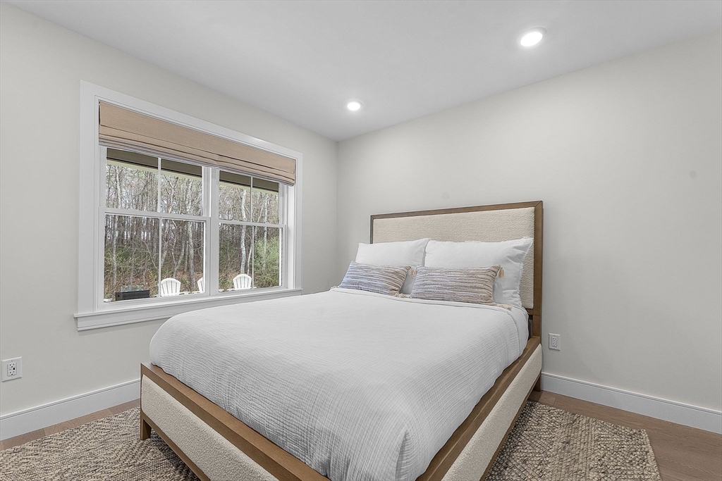 28 Oxbow Road, Unit 142 Raynham, MA 02767 - Photo 30 of 42 a large bed sitting in a bedroom next to a window