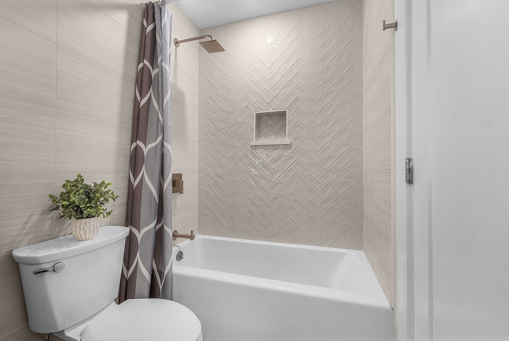 28 Oxbow Road, Unit 142 Raynham, MA 02767 - Photo 32 of 42 a bathroom with a toilet and a bath tub