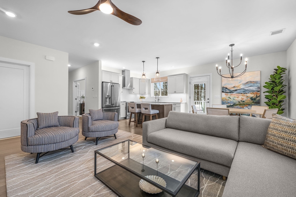 28 Oxbow Road, Unit 142 Raynham, MA 02767 - Photo 8 of 42 a living room with furniture kitchen view and a chandelier